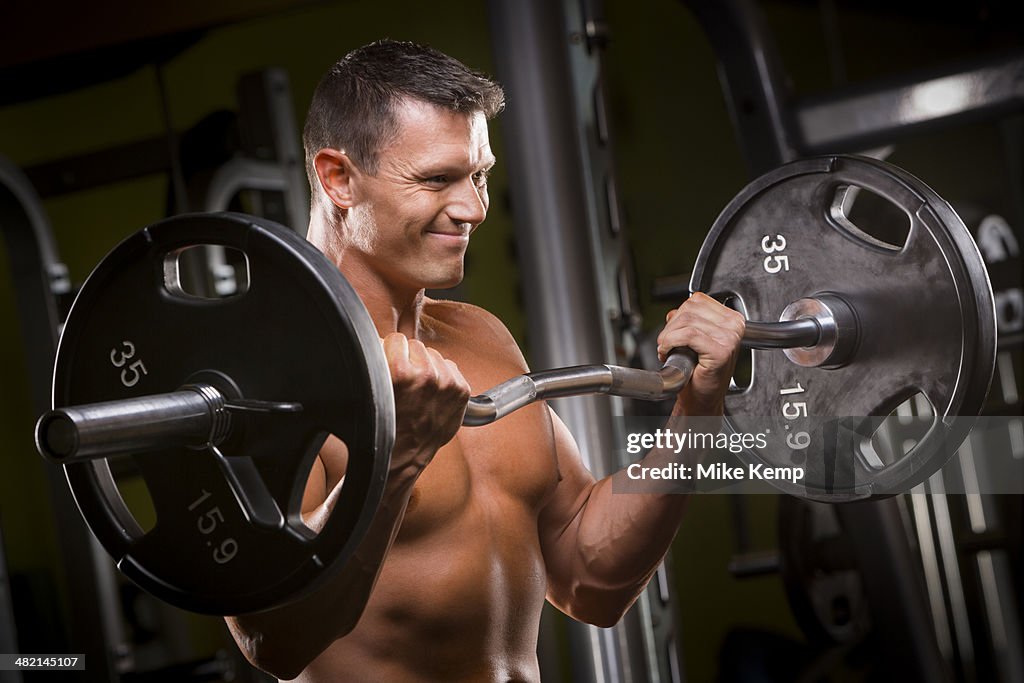 Caucasian man lifting barbell in gym