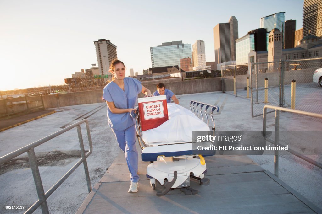 Caucasian nurses rushing organs and patient on rooftop