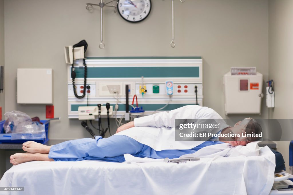 Caucasian doctor sleeping on hospital bed
