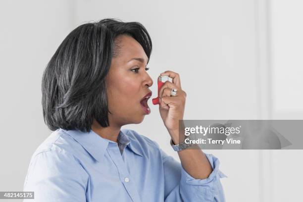 african american woman using asthma inhaler - mouth open profile stock pictures, royalty-free photos & images