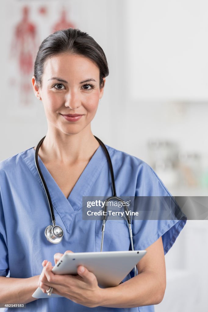 Portrait of confident mixed race nurse with digital tablet