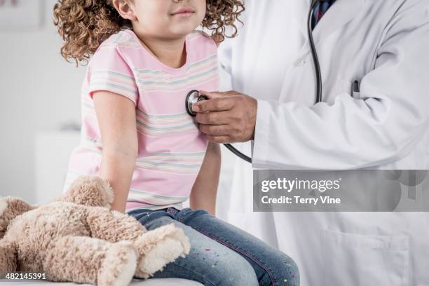 close up of doctor checking girl's heart with stethoscope - pédiatre photos et images de collection