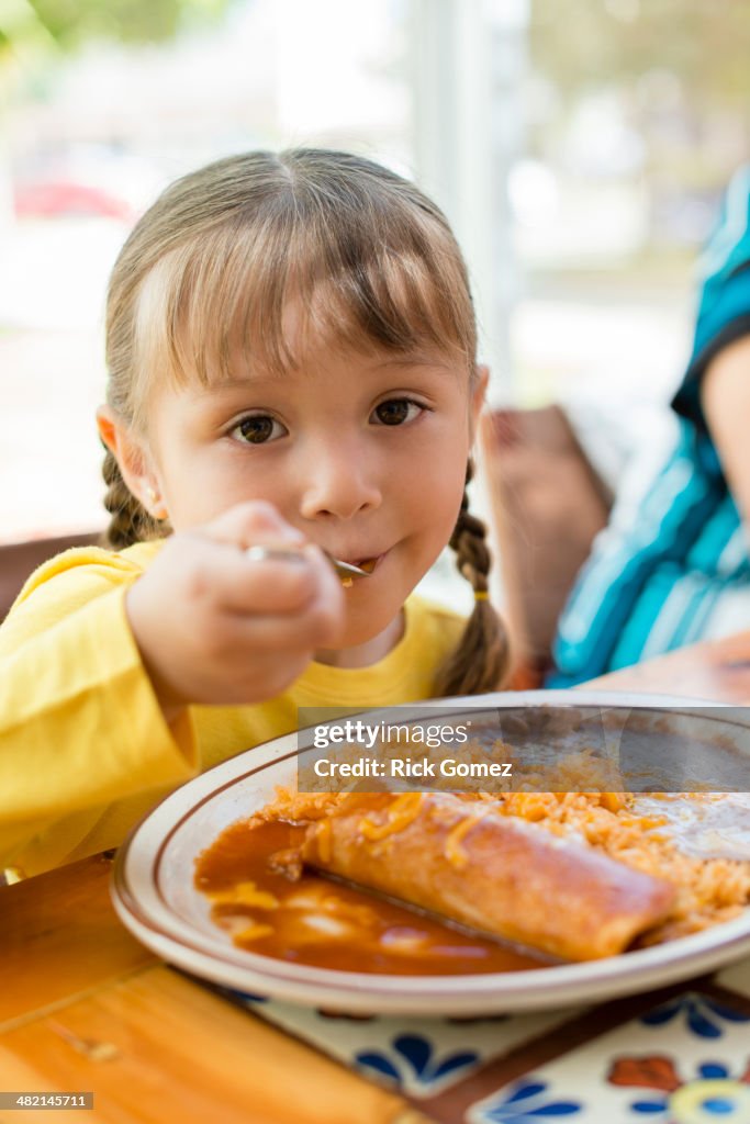 Hispanic girl eating dinner at table