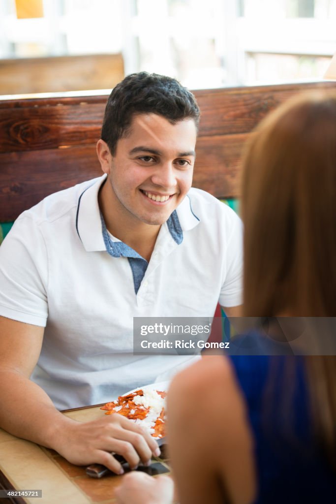 Hispanic couple eating together at cafe