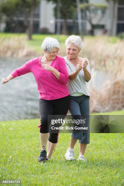 senior caucasian women playing in park - mature women dancing stock pictures, royalty-free photos & images