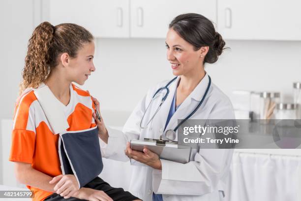 doctor talking to girl with arm in sling - kind mit armschlinge stock-fotos und bilder