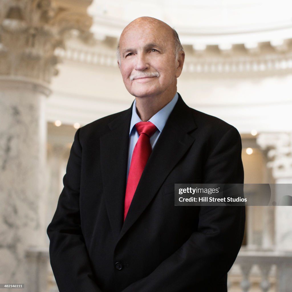 Caucasian politician smiling in government building