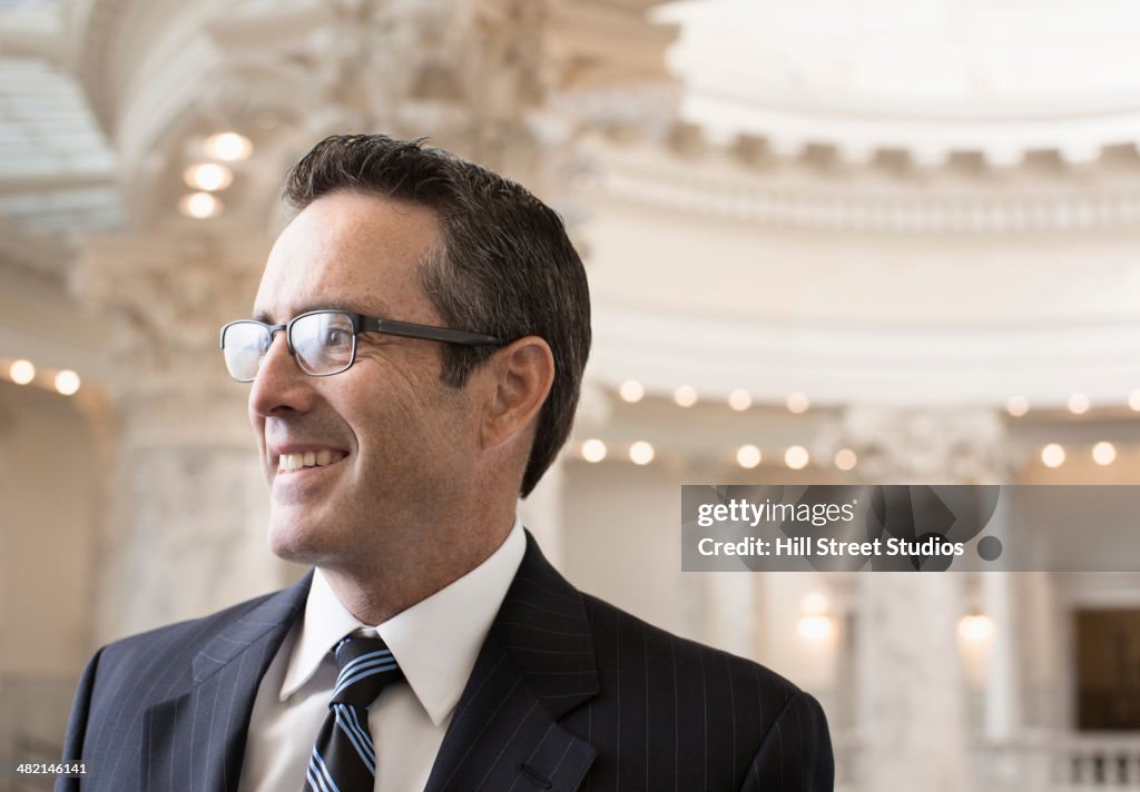 Caucasian politician smiling in government building