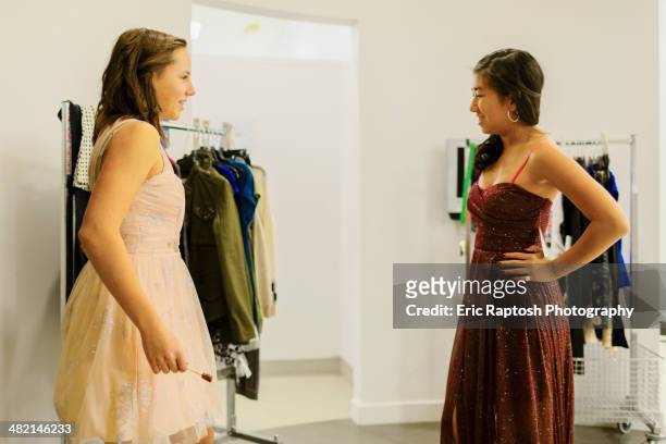 girls trying on prom dresses in clothing store - girl changing room shop stock-fotos und bilder