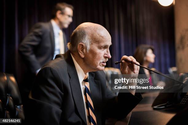 caucasian politician at microphone in chamber - working to get big money out of politics forum stockfoto's en -beelden