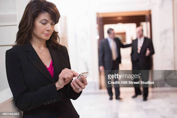 caucasian politician using cell phone in government building - democracy vote stock pictures, royalty-free photos & images
