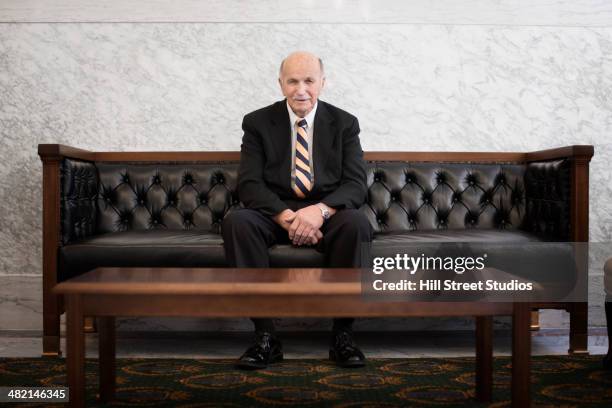 caucasian politician sitting in lobby of government building - politician portrait stock pictures, royalty-free photos & images