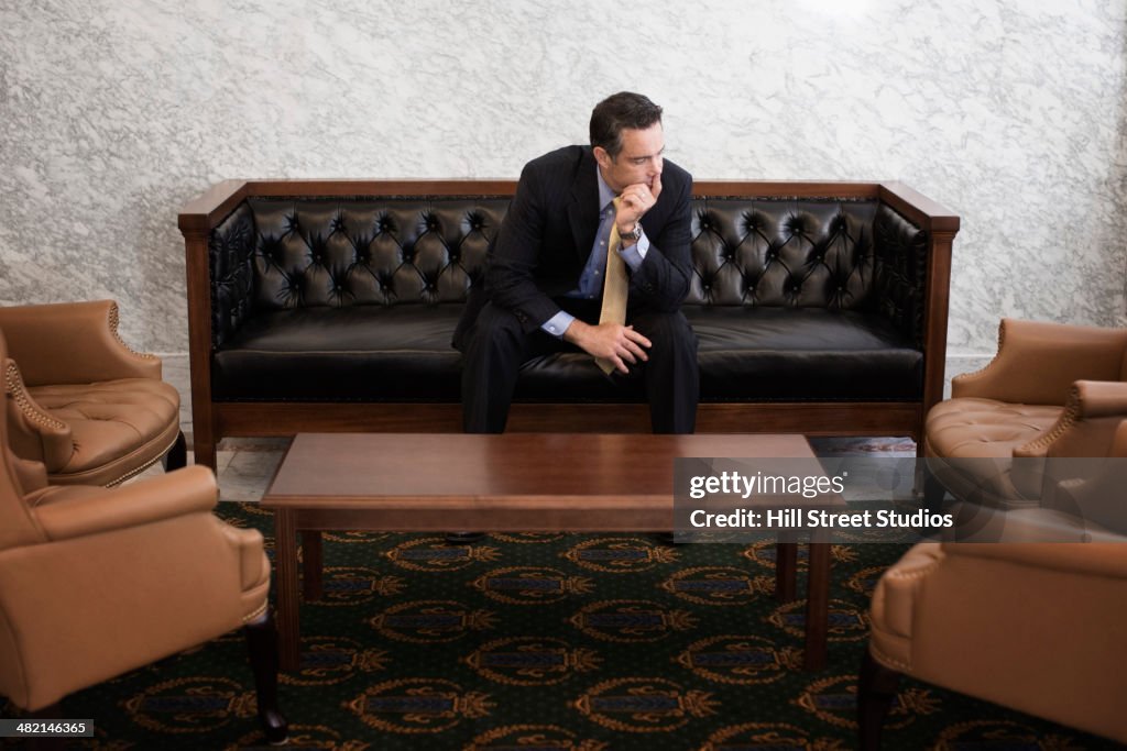 Caucasian politician sitting in lobby of government building