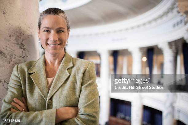 caucasian politician smiling in government building - overheidsberoep stockfoto's en -beelden