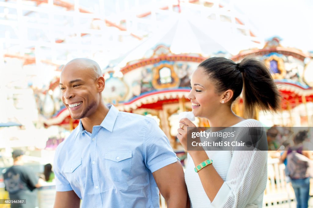 Mixed race couple laughing at amusement park