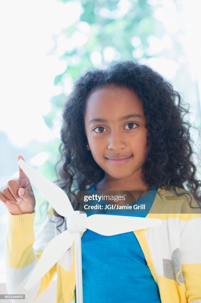 Mixed race girl with model wind turbine