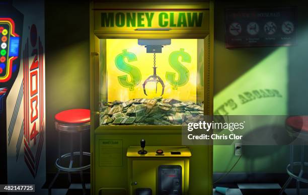 claw grabbing money in money claw arcade machine - 爪 個照片及圖片檔