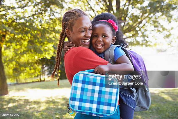 mixed race mother and hugging daughter - beginn des schuljahres stock-fotos und bilder