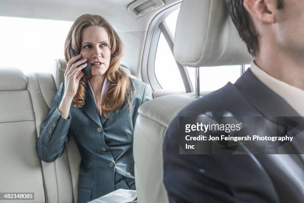 businesswoman talking on cell phone in car - chauffeur 個照片及圖片檔