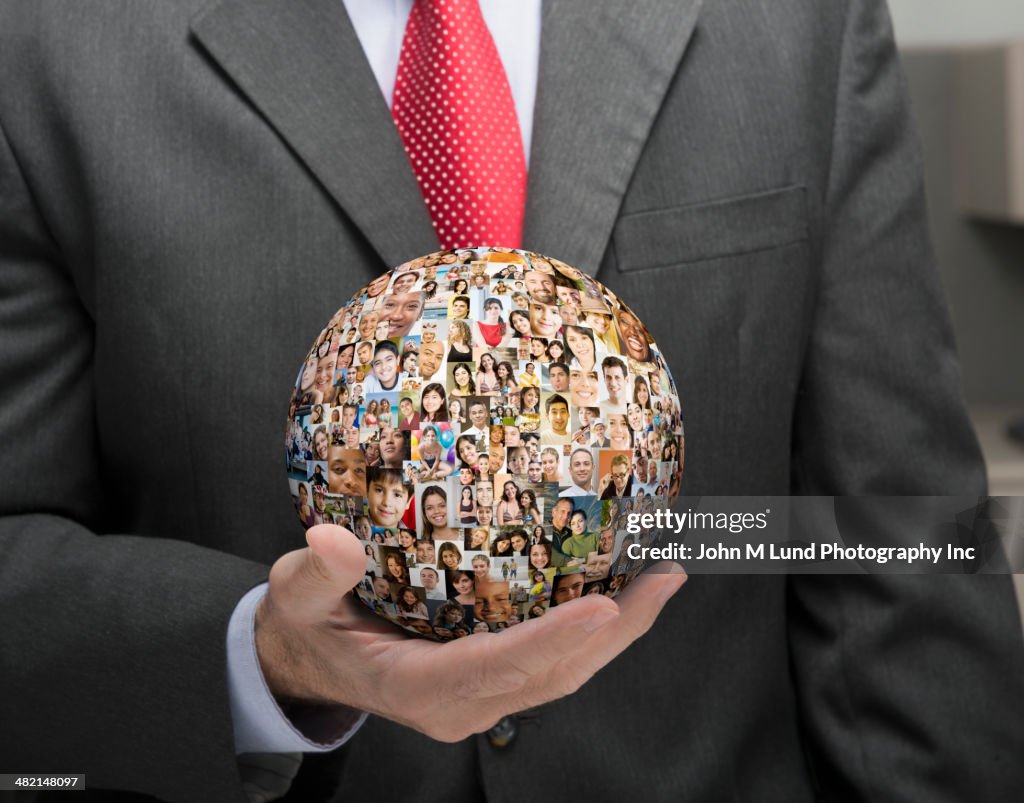 Businessman holding globe collage of business people's faces