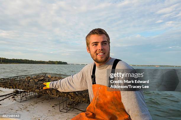 caucasian fisherman holding net on boat - fisherman stock photos et images de collection