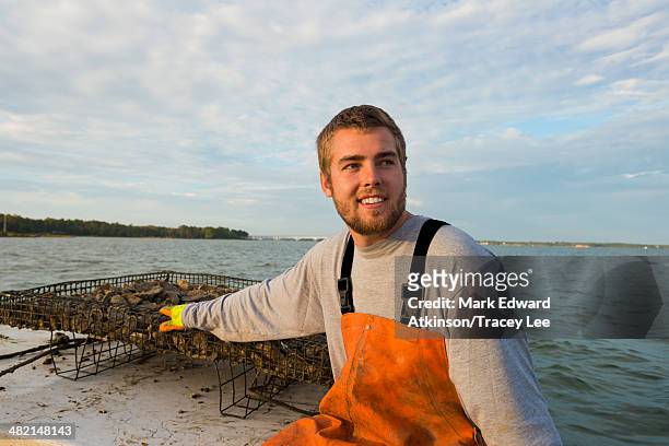 caucasian fisherman holding net on boat - young men fishing stock pictures, royalty-free photos & images