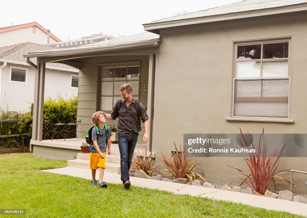 Caucasian father walking son to school