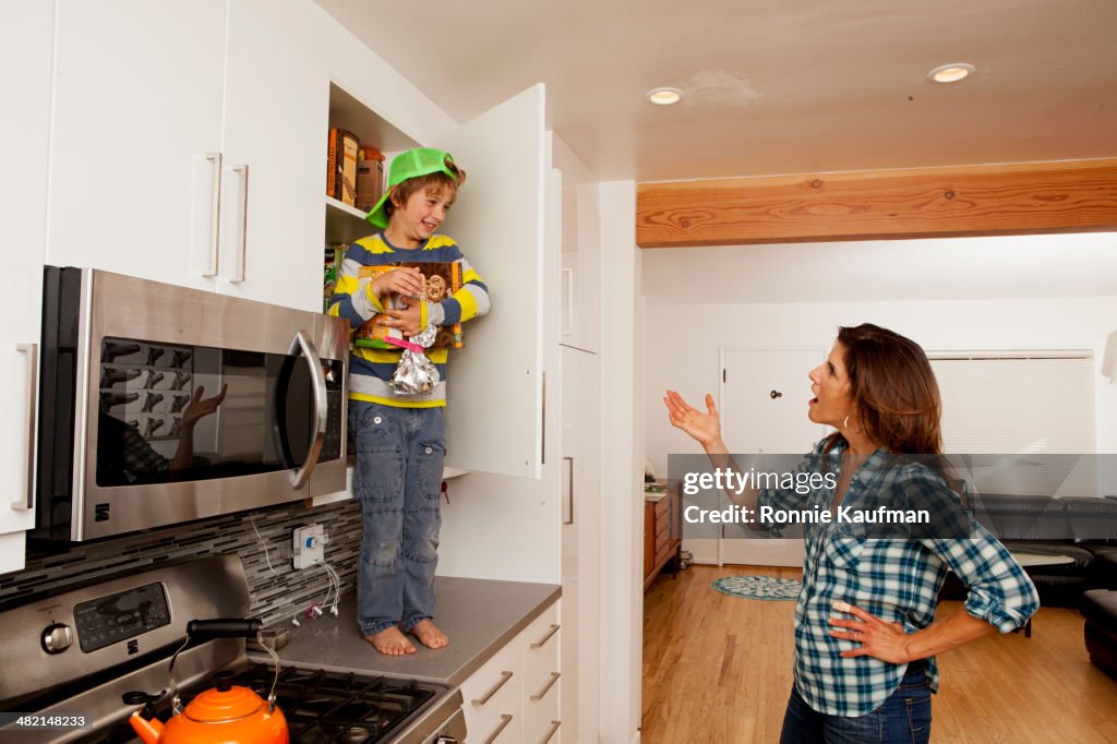 Caucasian mother scolding son on counter top