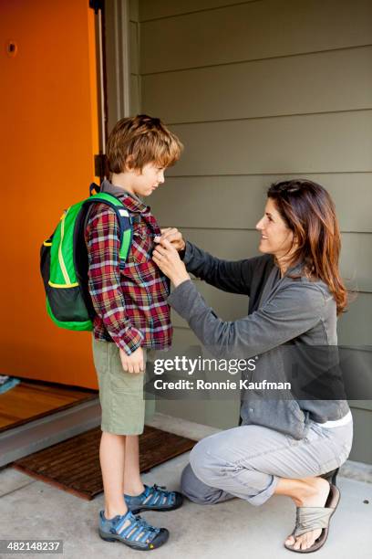 caucasian mother buttoning son's shirt - leaving school imagens e fotografias de stock