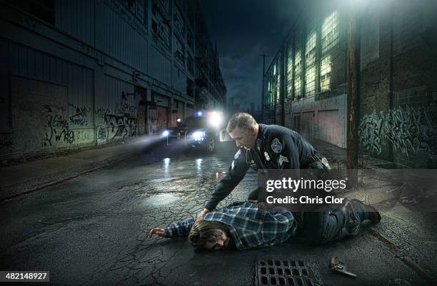 policeman arresting man on city street - car crime stock pictures, royalty-free photos & images