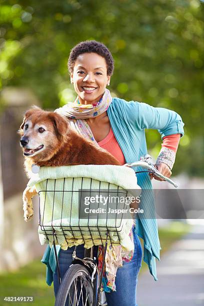 black woman carrying dog in bicycle basket - panier de bicyclette photos et images de collection