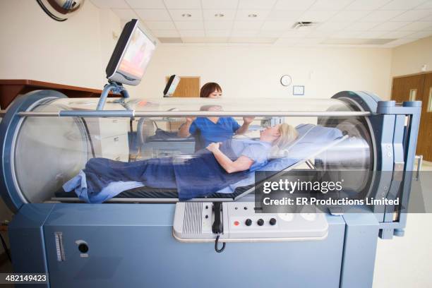 patient laying in hyperbaric chamber - rapporto medico paziente foto e immagini stock
