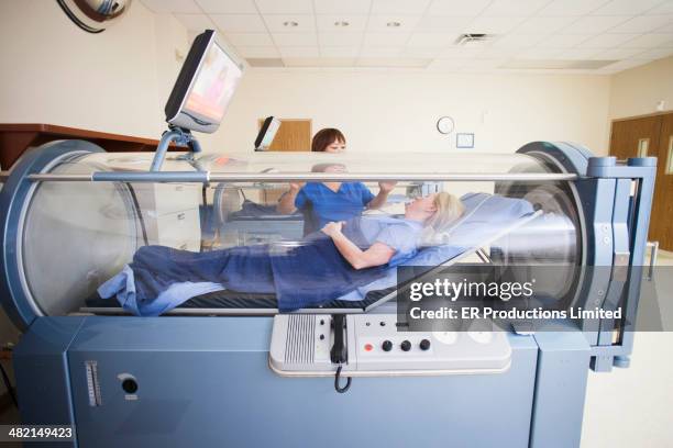 patient laying in hyperbaric chamber - bedside manner stock pictures, royalty-free photos & images