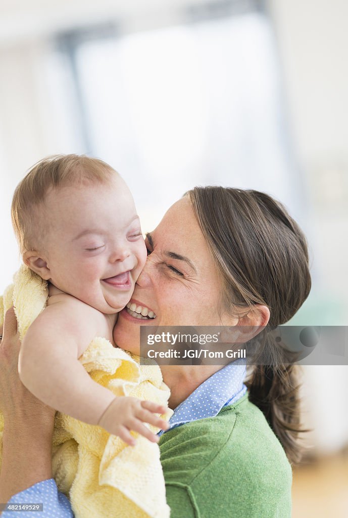 Caucasian mother playing with baby girl with Down Syndrome