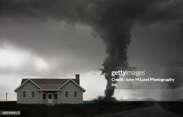 tornado approaching house in rural landscape - furacão imagens e fotografias de stock