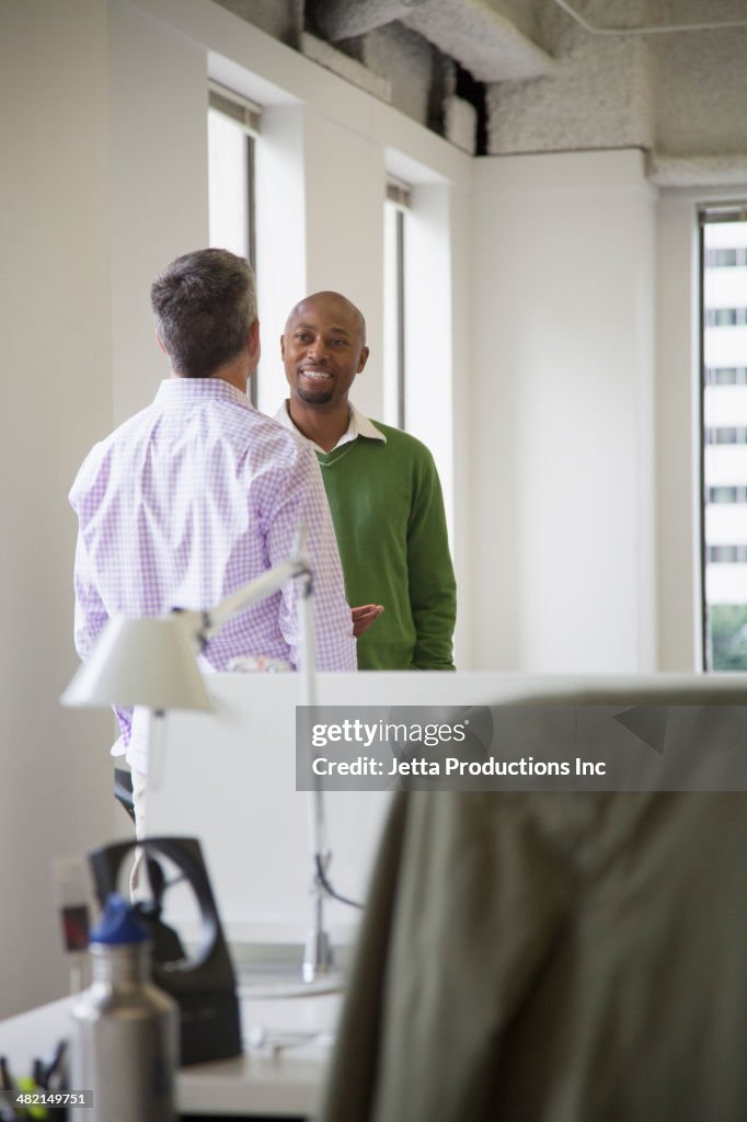 Businessmen shaking hands in office