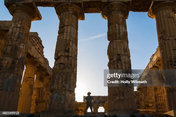 caucasian man standing in temple at selinunte ruins, selinunte, sicily, italy - arqueologo imagens e fotografias de stock