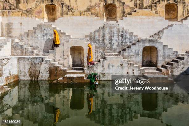 women in saris carrying water at step well, jaipur, rajasthan, india - jaypour photos et images de collection