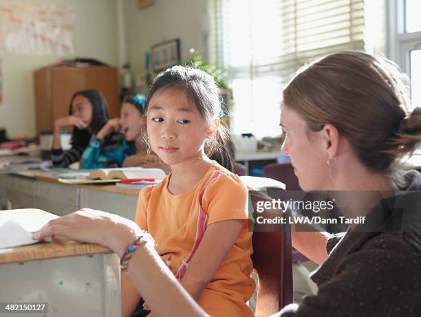 student working with teacher in class - overworked teacher stock pictures, royalty-free photos & images