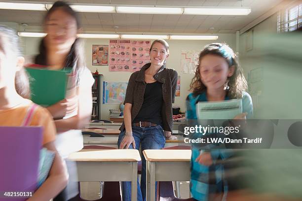 teacher watching students leave classroom - kind vor der pubertät stock-fotos und bilder