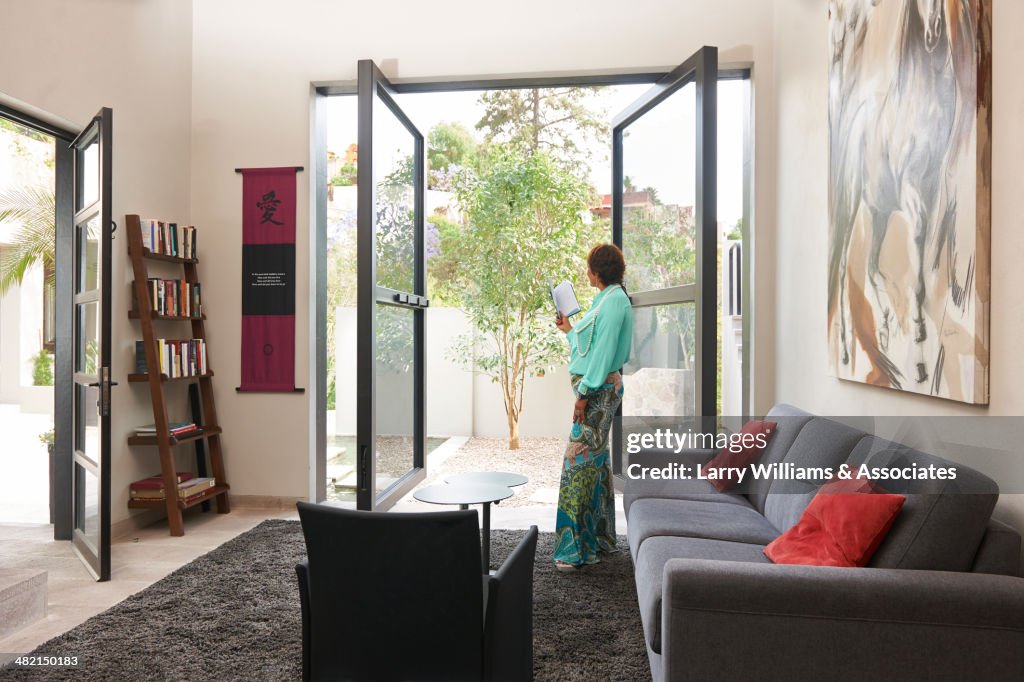 Hispanic woman standing at glass doors