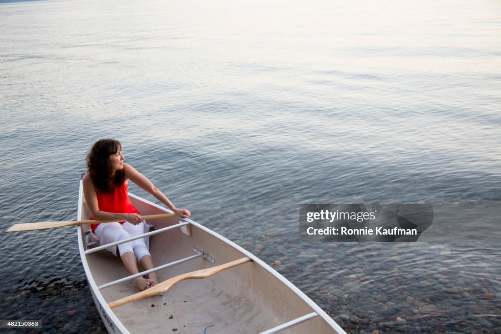 Caucasian woman sitting in canoe in lake