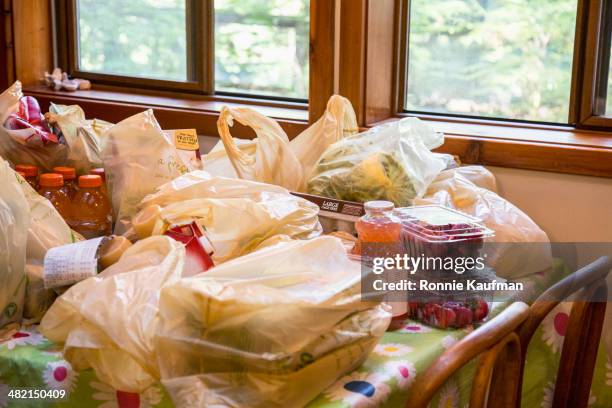 bags of groceries on dining room table - sac en plastique photos et images de collection