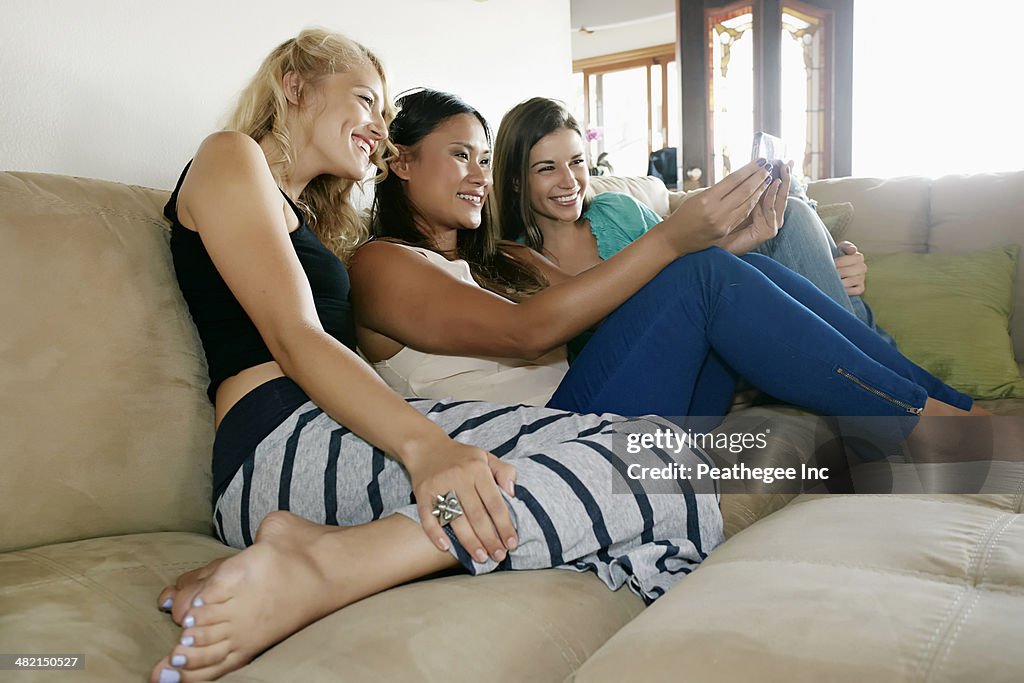 Women taking self-portrait together on sofa