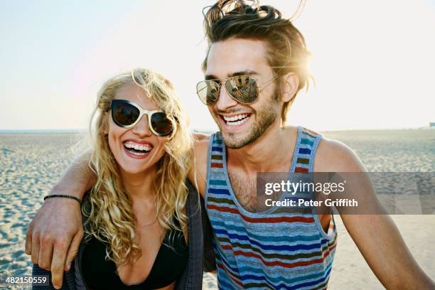 couple smiling together on beach - couple at beach sunny stock pictures, royalty-free photos & images