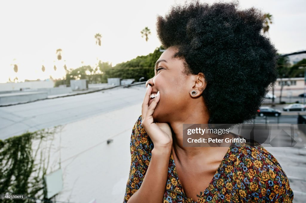 Black woman smiling on urban rooftop