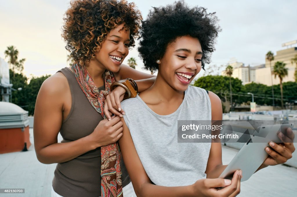 Women using digital tablet on urban rooftop