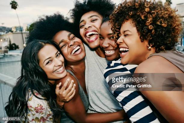 women laughing together on urban rooftop - nur frauen stock-fotos und bilder