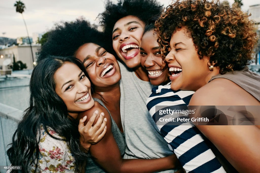 Women laughing together on urban rooftop