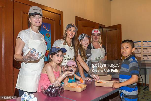 Betsy Brandt, Samantha Harris, Lola Ray Facinelli, Jennie Garth, Hillary Madison Hess , and Josselyn Sydney Hess serve lunch to kids at the Feeding...